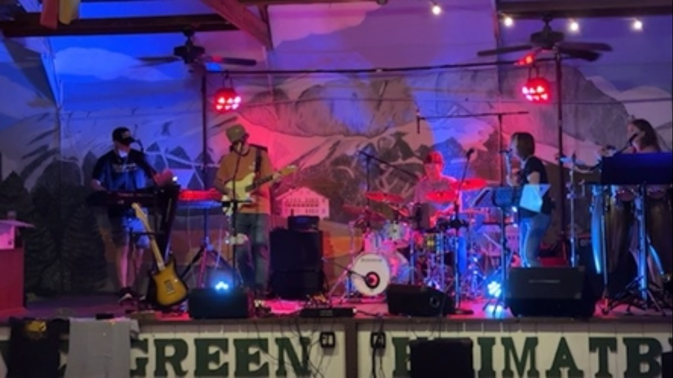 Reality Chick playing a live set on stage under red and blue lights